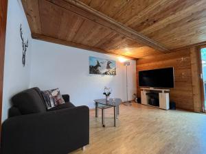 a living room with a couch and a flat screen tv at Lomatte 1758 in Saas-Fee