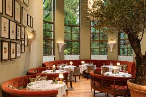 a restaurant with tables and chairs and windows at Rocco Forte The Charles Hotel in Munich