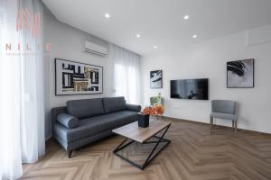 Serene, Nilie Hospitality MGMT في سلانيك: غرفة معيشة مع أريكة وطاولة