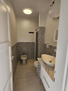 ein Badezimmer mit Waschbecken und Toilette in der Unterkunft Casa prima fila con Vista Mare in Isola Rossa + 29 Fotos