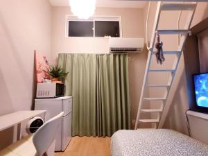 a room with a staircase and a green curtain at Glen Stage 中浦和 in Saitama