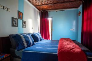a bedroom with a bed with blue and red at Gite akswal amssakrou in Ikis
