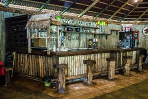 玛丽亚达费Pousada Shambhala的一间木酒吧,里面设有凳子