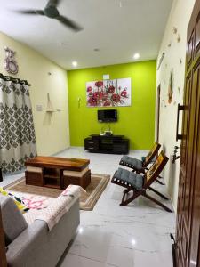 ein Wohnzimmer mit Sofa und Fernseher in der Unterkunft Sri Bairav Cottage in Madurai + 16 Fotos