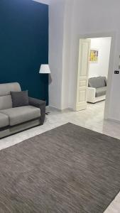ein Wohnzimmer mit einem Sofa, einer Tür und einem Teppich in der Unterkunft BB casa vacanza in Catania