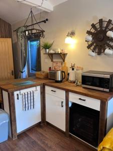 a kitchen with a wooden counter top with a microwave at Welcoming Warm Spring Cabin! in Shiplake