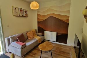 a living room with a couch and a table at Le Cocon Terracotta & Spa in Saint-Laurent-de-Médoc