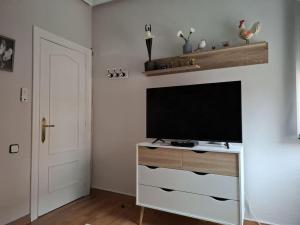 a living room with a flat screen television on a dresser at CASA RAMI especial parejas in San Martín del Rey Aurelio