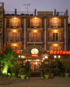 a hotel building with a clock in front of it at Greek House Hotel in Neos Marmaras