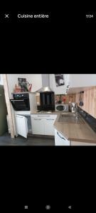 Friville-EscarbotinにあるAppartement spacieuxの白いキャビネットとシンクのあるキッチン