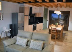 a living room with a couch and a kitchen with a table at Casas Las Hazas in La Cuesta