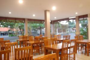 a empty restaurant with wooden tables and chairs at Hotel Dhyana Pura in Kapal
