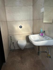 a bathroom with a sink and a toilet at Sunny Executive in Satara