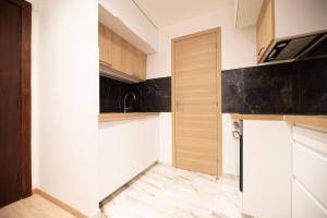 ルヴァロワ・ペレにあるAppartement confortable et moderne - centreのキッチン(白と黒のカウンター、冷蔵庫付) +2枚の写真