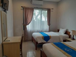 a hotel room with two beds and a window at Hotel Dhyana Pura in Kapal +34 photos