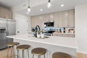 een keuken met witte kasten en een aanrecht met krukken bij Life is Good condo in Atkinville