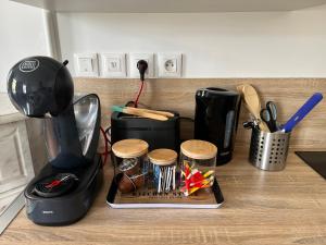 a kitchen counter with a coffee maker and a blender at Raffiné - Literie haut de gamme - Parking Gratuit - Central - WIFI rapide in Bapaume +15 photos