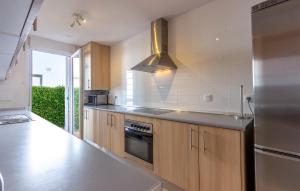 a kitchen with wooden cabinets and a stainless steel refrigerator at Gorgeous Home In Condado De Alhama in El Romero