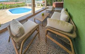 un patio con 2 sedie, un tavolo e una piscina di Stunning Home In Razanj a Ražanj