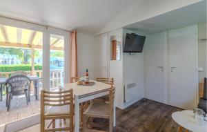 salon ze stołem i krzesłami oraz balkonem w obiekcie Pet Friendly Stacaravan In Les Mathes w mieście Les Mathes
