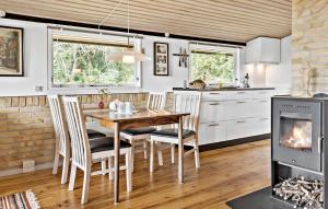 a kitchen with a table and chairs and a fireplace at 4 Bedroom Cozy Home In Jægerspris in Jægerspris
