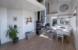 a kitchen and dining room with a table and a clock at 3 Bedroom Gorgeous Home In Lyngdal in Lyngdal