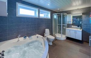 a large bathroom with a tub and a toilet at 3 Bedroom Gorgeous Home In Lyngdal in Lyngdal +10 photos