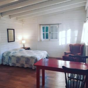 a bedroom with a bed and a table and a chair at Miralrio in Santa Rosa de Calamuchita