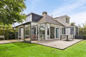 ein Anbau eines Hauses mit Terrasse und Rasen in der Unterkunft Vakantiewoning voor het gezin in Stavenisse in Stavenisse