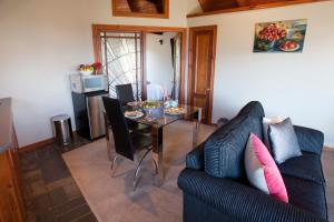 a living room with a table and a black couch at Kauri House Apartment in Wanaka