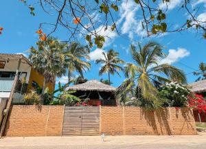 a brick fence in front of a house with palm trees at KazaBrasil in Icaraí +6 photos