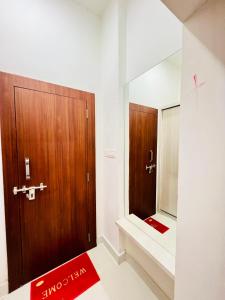 a bathroom with a wooden door and a mirror at Agariya Pool Villa near Lake pichola in Udaipur