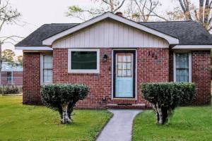 ein rotes Backsteinhaus mit einer Tür und zwei Büschen in der Unterkunft Cozy, Contemporary Haven Near Historic Downtown in Savannah