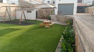 un patio trasero con una mesa de picnic y una sombrilla en Casa El Obrador, en Arguedas