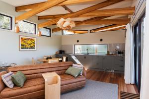 a living room with a couch and a kitchen at Freycinet Resort in Coles Bay
