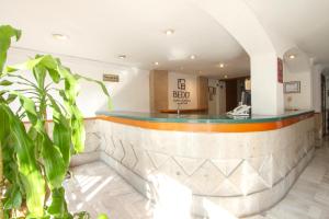eine Bar in einem Gebäude mit einer Pflanze in der Unterkunft Hotel Bedd Express Querétaro in Querétaro