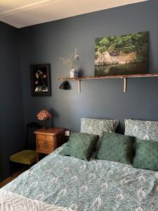 - une chambre avec un lit doté d'oreillers verts dans l'établissement Charmante maison de village, à Sénaillac-Lauzès