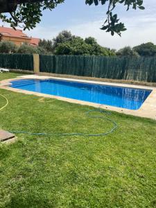 a swimming pool in a yard with a hose at La Casita del Cerro in Candeleda