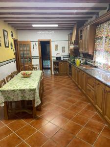 a large kitchen with a table and a counter top at La Casita del Cerro in Candeleda