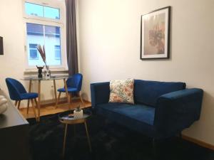 a living room with a blue couch and a table at Designer Wohnung Erfurt Auenstr in Erfurt