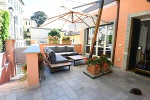 a patio with a couch and an umbrella at Casa Pini in Bellagio