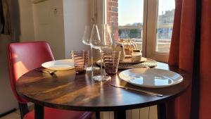 a wooden table with plates and glasses on it at Gite Urbain - Dionysos - Parking in Épernay