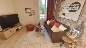 a living room with a couch and a tv at Gite Urbain - Dionysos - Parking in Épernay