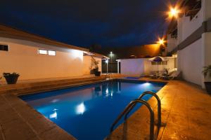 ein Swimmingpool in einem Garten bei Nacht in der Unterkunft Hotel Bedd Express Querétaro in Querétaro