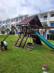 a playground in a park with a slide at Très bel Appartement avec Piscine et Jardin in Mansouria