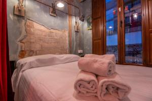 a bedroom with a bed with towels on it at El café Paris de apartamentos CV in Granada