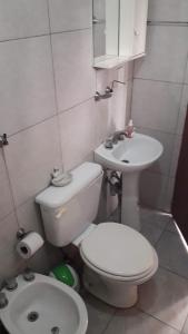 Un baño pequeño con inodoro y lavabo. en turismo chascomus, en Chascomús