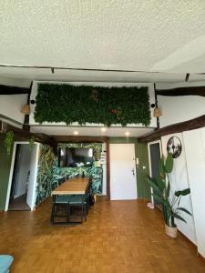 a living room with a table and plants on the wall at Jungle Cosy in Louviers