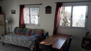 sala de estar con sofá, mesa y ventanas en turismo chascomus, en Chascomús
