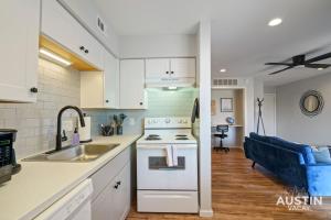奥斯汀Comfy ATX Apt plus Balcony and Smart TV and Free Parking的带水槽和炉灶的厨房 顶部烤箱